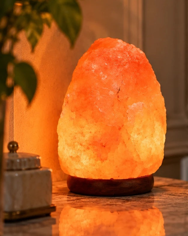 Himalayan salt lamp on a marble side table, its warm glow reflected below